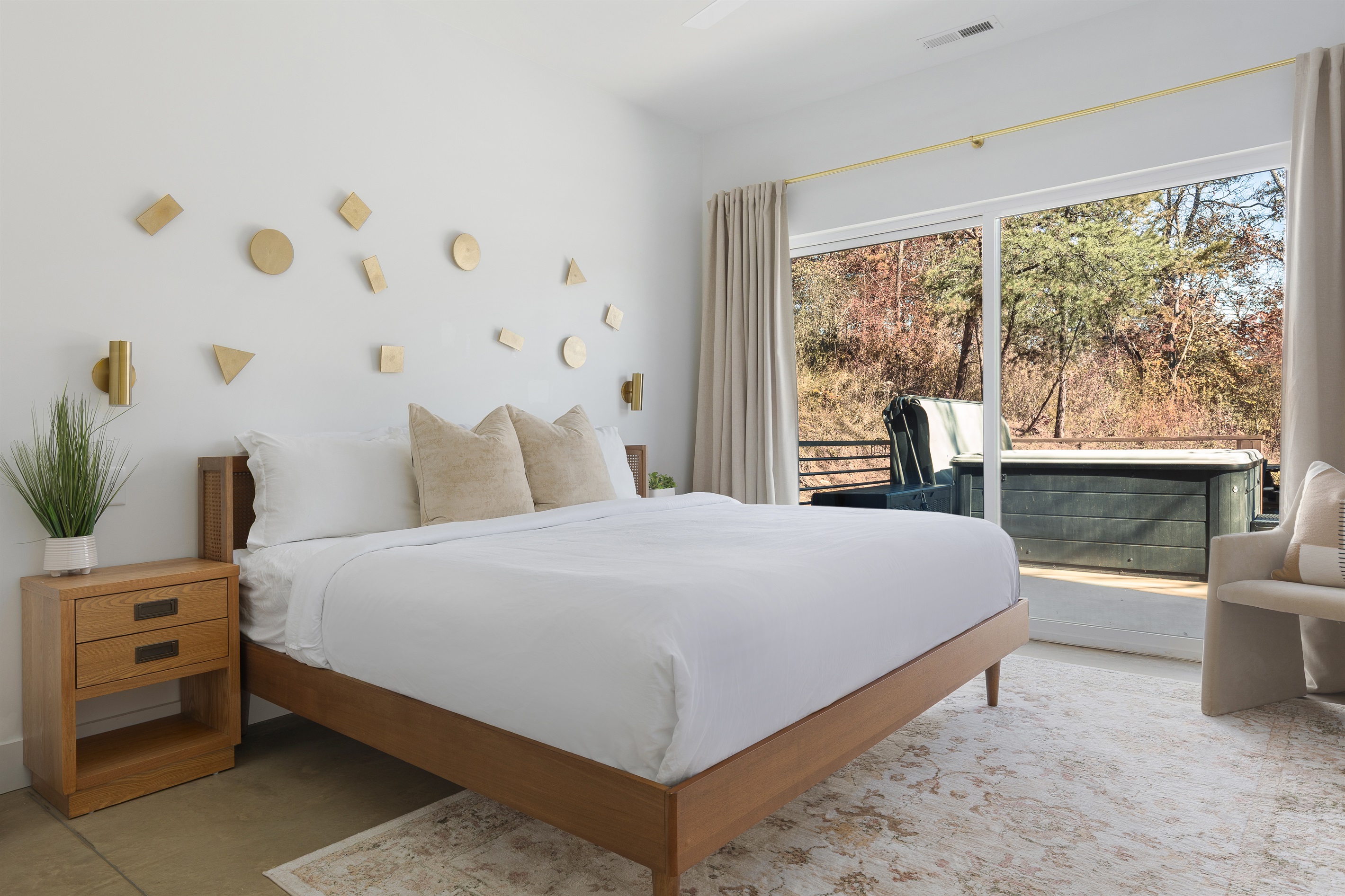{King Suite - Gallery House} A sunlit bedroom with layered textures and direct access to your private hot tub—relaxation begins the moment you wake.