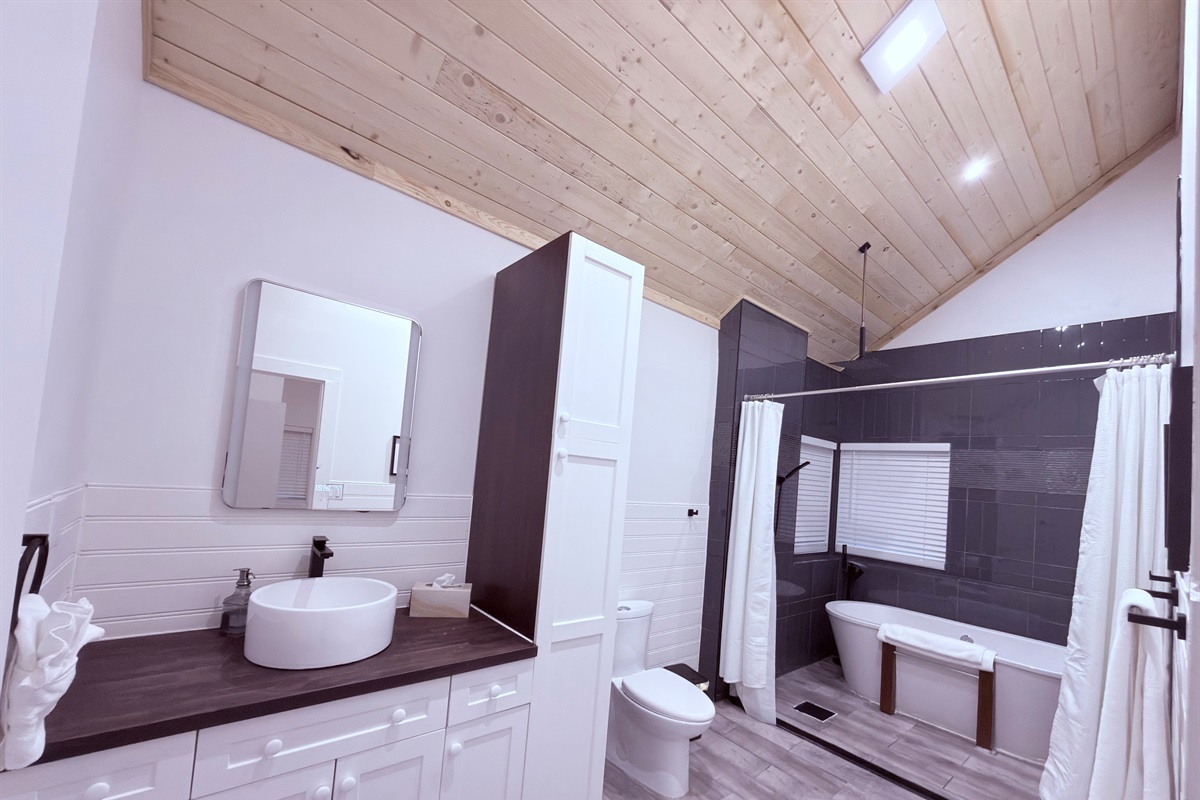 Spacious primary ensuite bathroom with modern vessel sink, walking shower and soaker tub