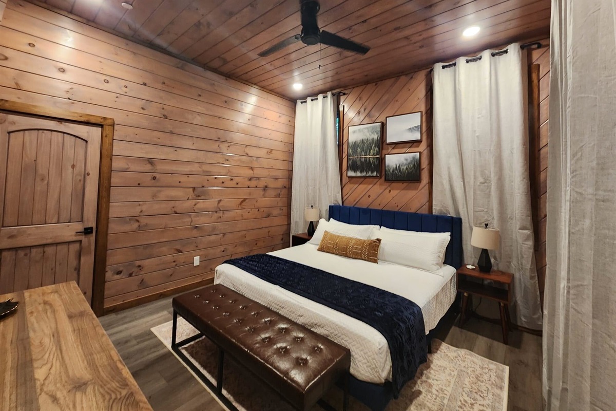 Spacious king bedroom with warm wood finishes and cozy charm.