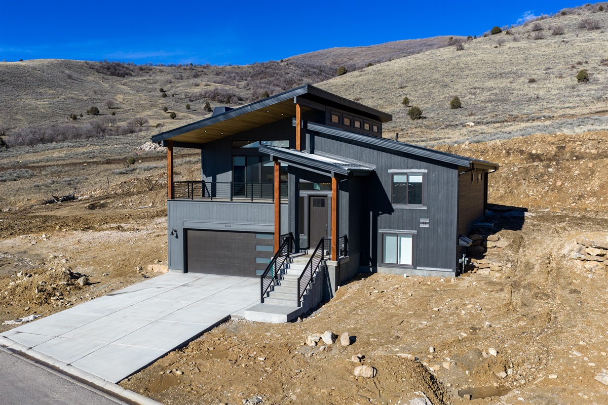 Contemporary mountain architecture with bold lines and a two-car garage.