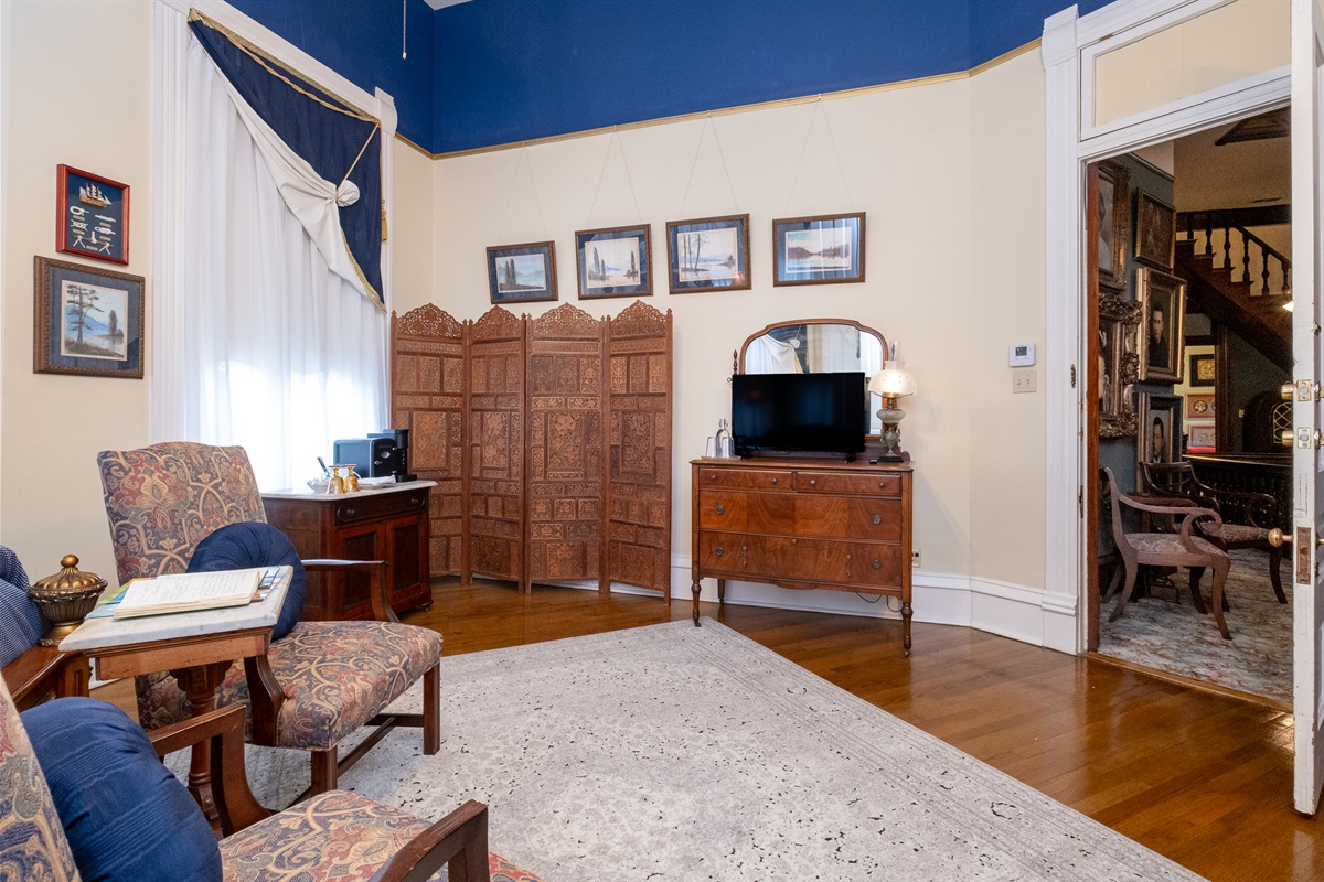 Petit Jean Suite sitting area with antique furnishings, original hardwood floors, and classic details.
