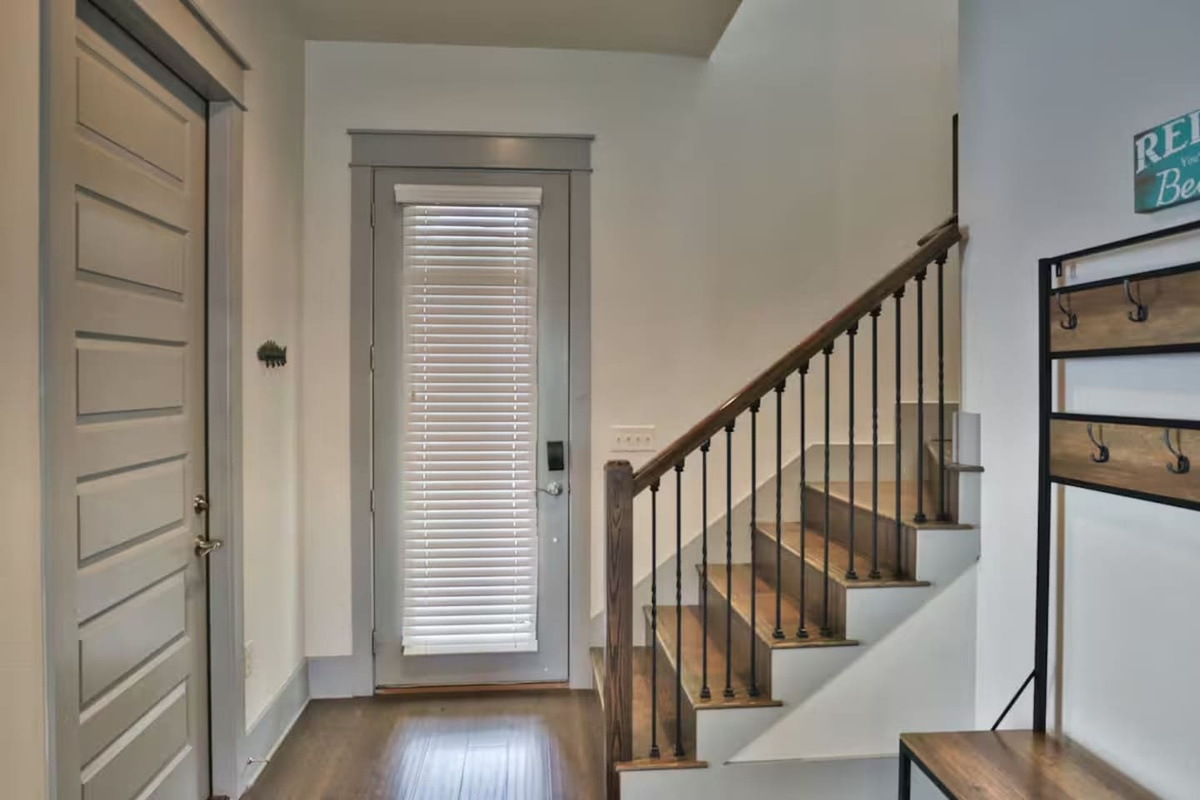 stairway connecting second floor with 3 bedrooms and first floor with 1 bedroom, living room and kitchen