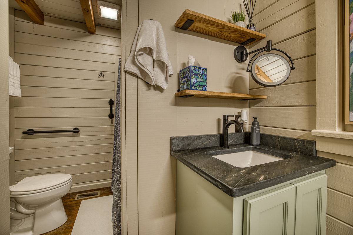Bathroom with a vanity and open shelf.