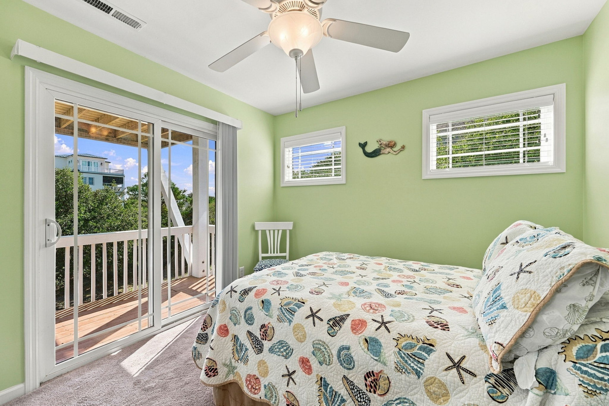 Unwind in this inviting lower-level queen bedroom, offering deck access and comfortable bedding. 