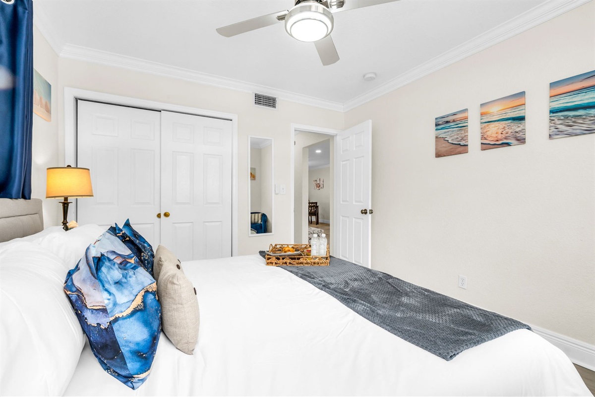 Unwind in the serene primary suite with a king bed, soft linens, and sunlit windows—your peaceful escape after a day at the beach.
