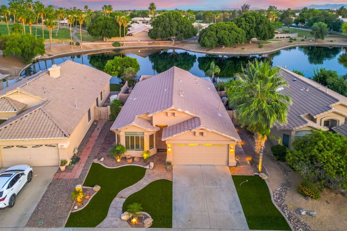 From above, the full picture comes into view — a beautifully kept home sitting right on the lake, surrounded by lush greenery and the natural beauty of the Arizona landscape.
