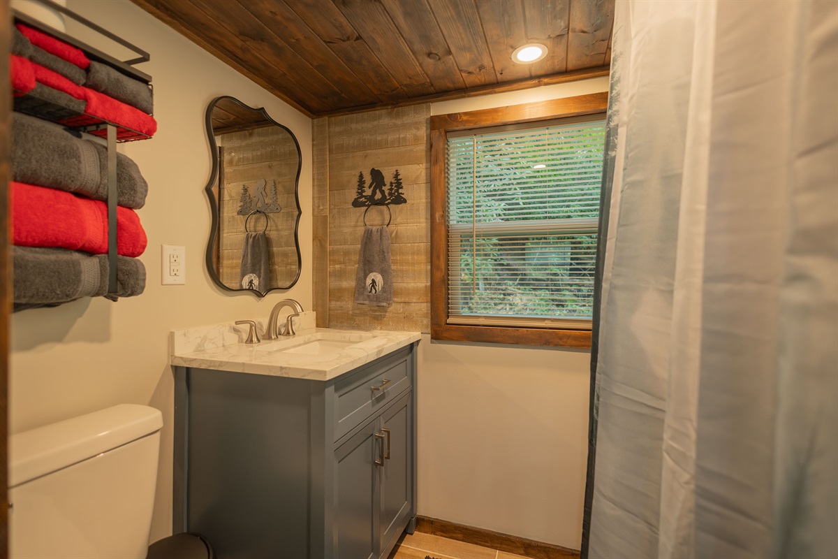 A full bathroom with a tiled shower, vanity, and thoughtful touches for a comfortable stay.