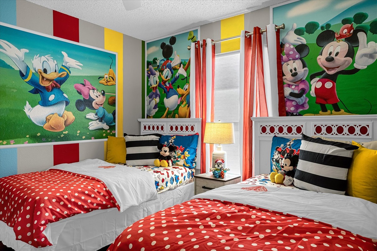 Children's bedroom featuring 2 twin beds with colorful Mickey and Friends decor