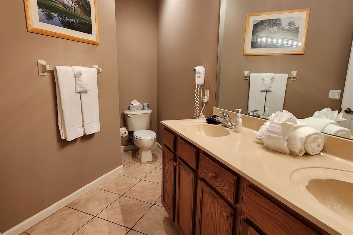 Spacious bathroom featuring a long vanity, tile flooring, and clean neutral finishes.