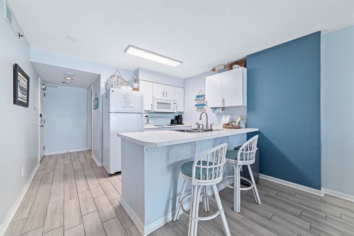 Sleek and sophisticated kitchen featuring a striking island with a stone countertop and comfortable bar stools.
