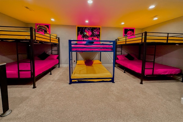 Massive bedroom featuring 2 queen-sized and 1 full-sized bunk beds, perfect for groups or families to stay in comfort