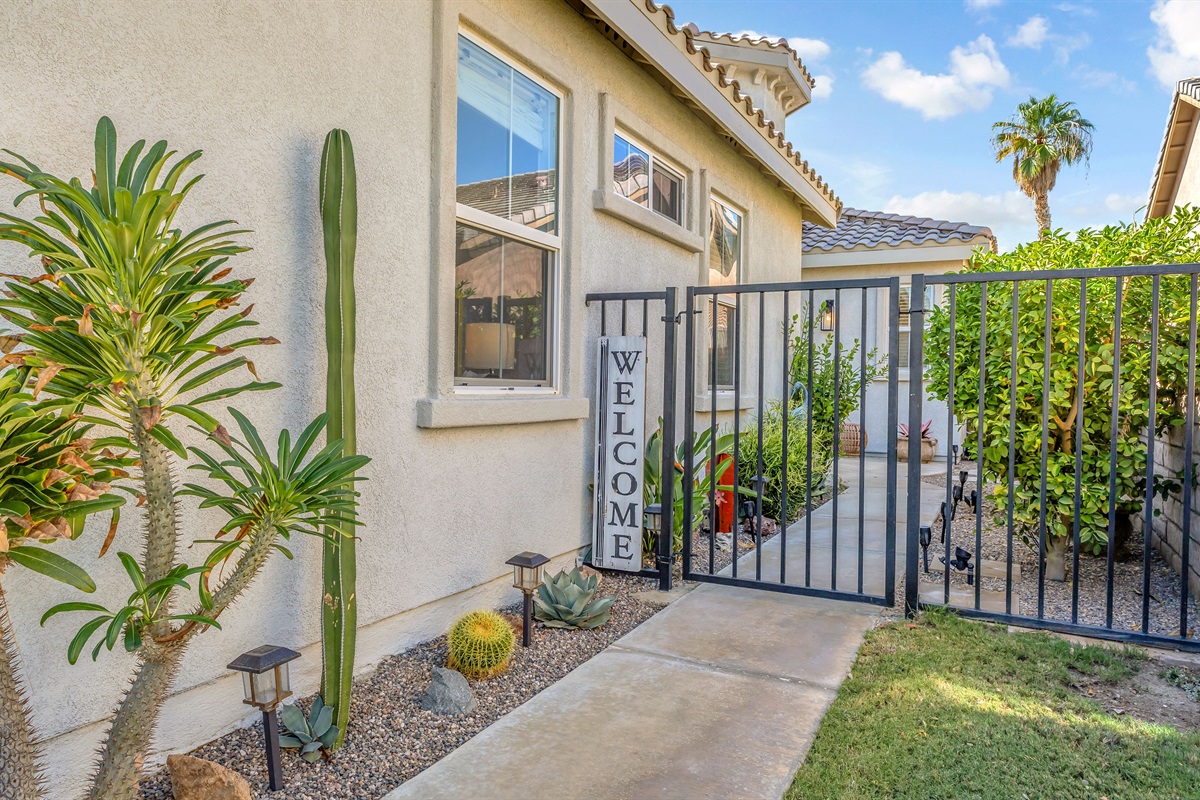 Welcoming gated entry with desert landscaping and charming cactus garden — your peaceful desert retreat begins here