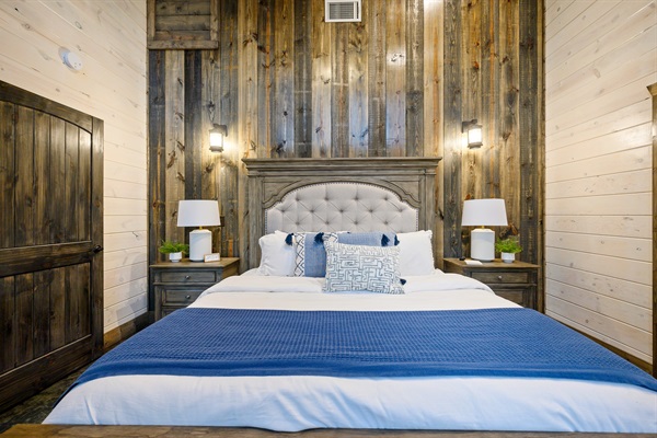 Elegant king suite with a plush tufted headboard and rustic wood accents.