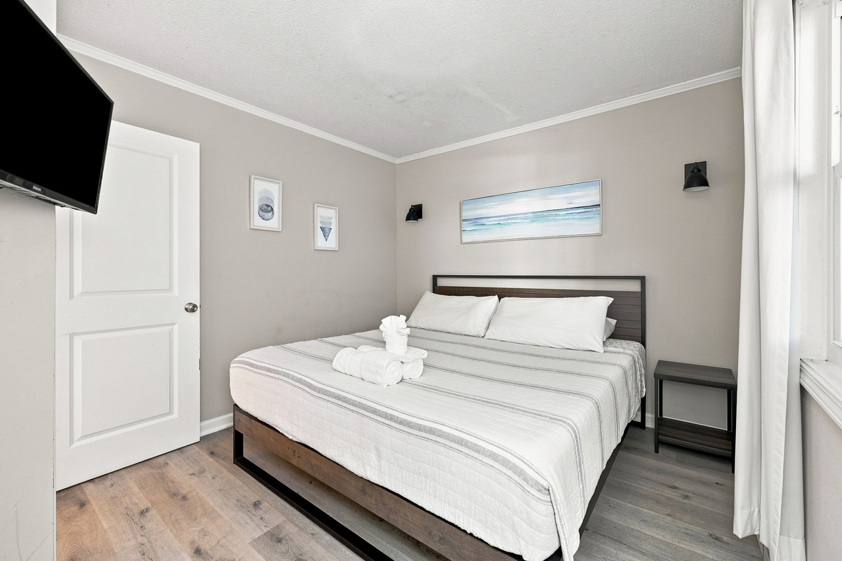 A bright and inviting bedroom with comfortable king bed, modern finishes, and everything needed for a restful stay