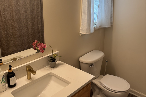 Private Primary en-suite bathroom with a quartz-topped vanity and full bath.