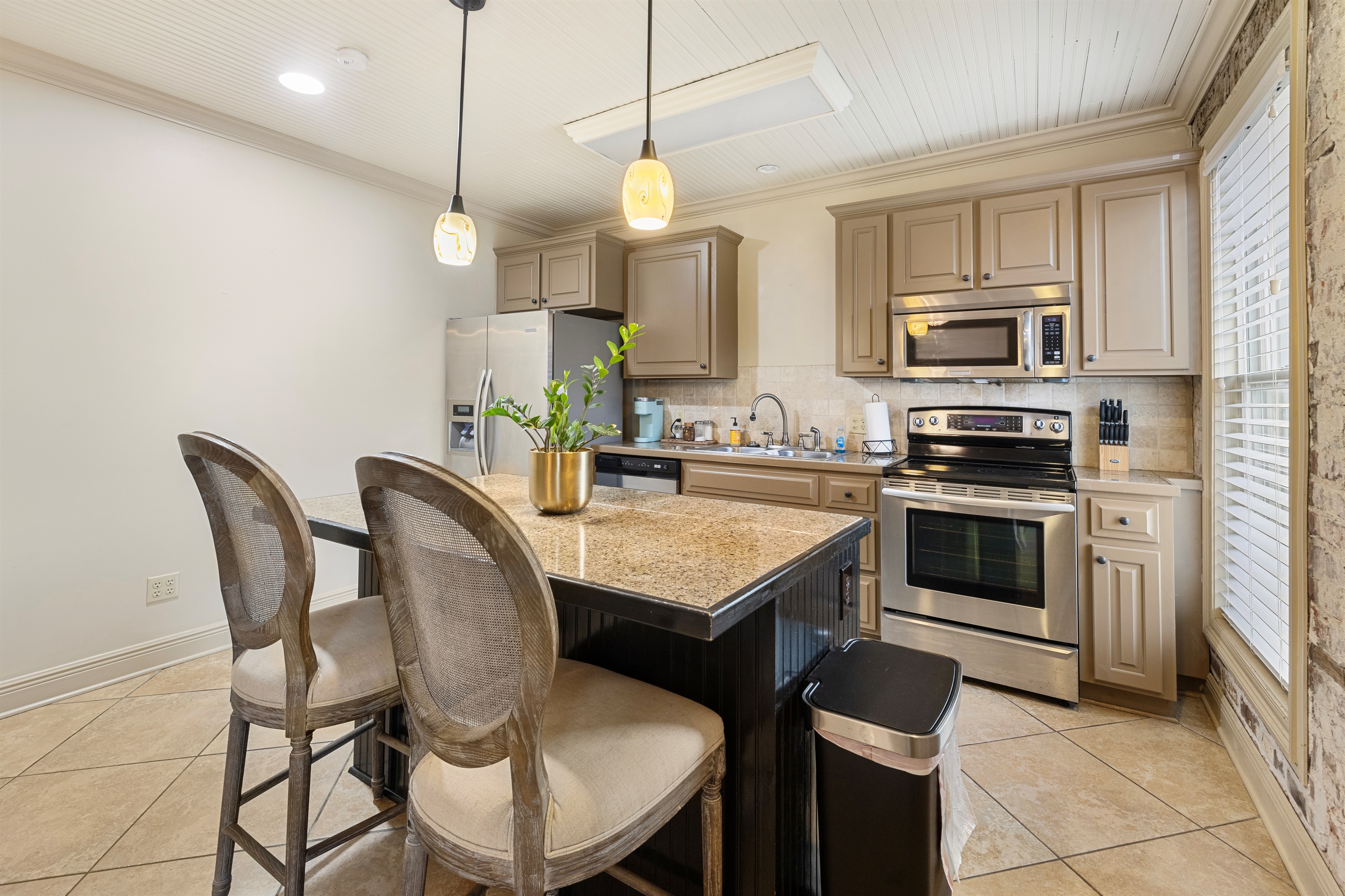 Sleek appliances, stylish island seating, and natural light make meal prep enjoyable