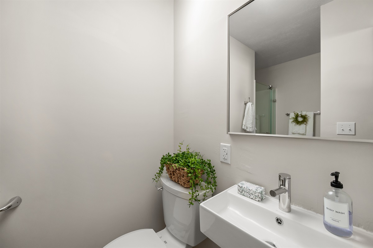 Full bathroom includes a toilet, sink, and spacious walk in shower with newly updated modern finishes.