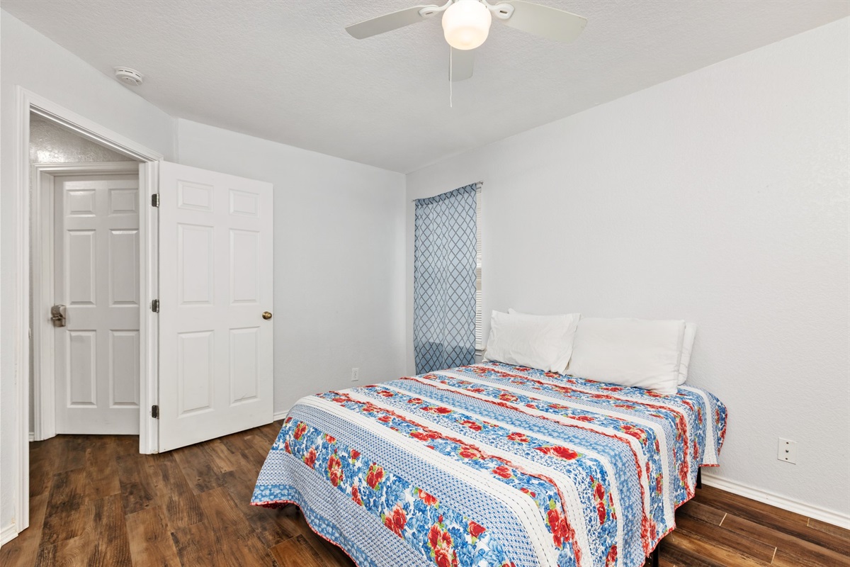 Queen bedroom with fresh hotel-quality linens, ceiling fan, room-darkening shades, and clothing storage. Extra pillows and blankets included. Current decorative blankets, bedding, and wall art are not shown in these photos.