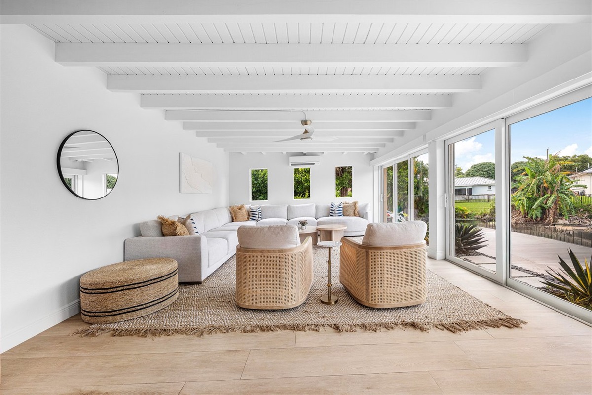 Breezy indoor-outdoor living defines this serene lounge, where sliding glass doors open to lush tropical surroundings.
