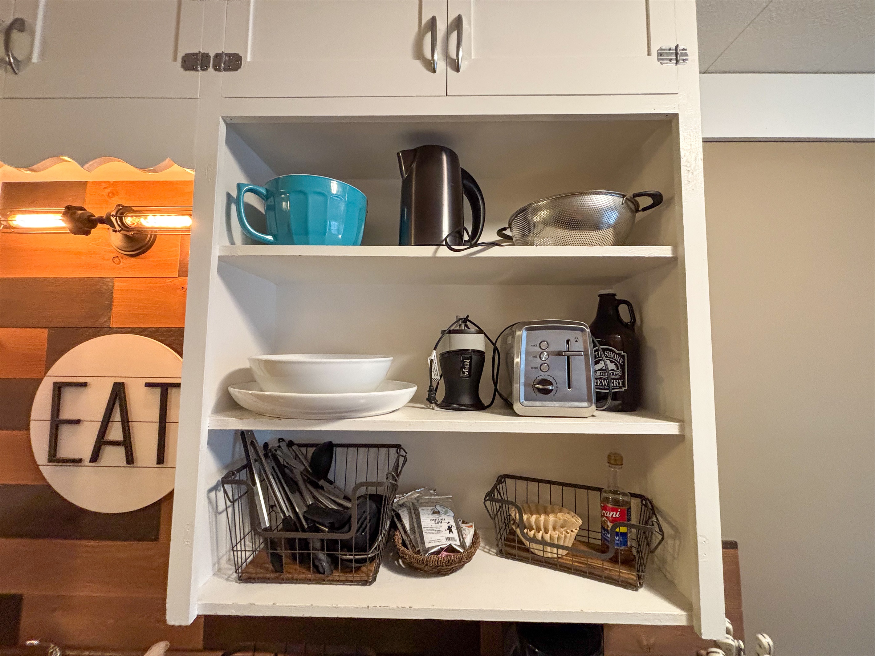 Modern and efficient—everything you need to create a delicious meal. The kitchen features a stainless steel refrigerator, stove, coffee maker, kitchenette oven, kettle, and blender