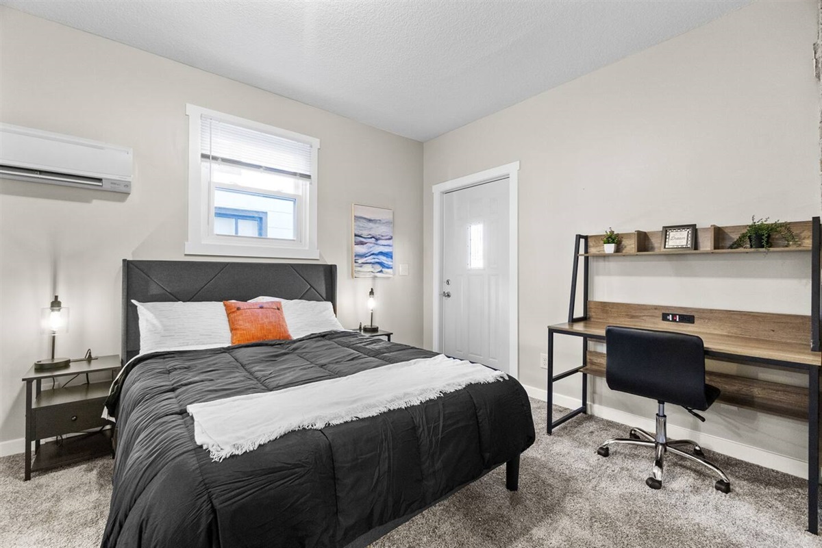 Cozy bedroom featuring a comfortable bed and a convenient desk for work or study.