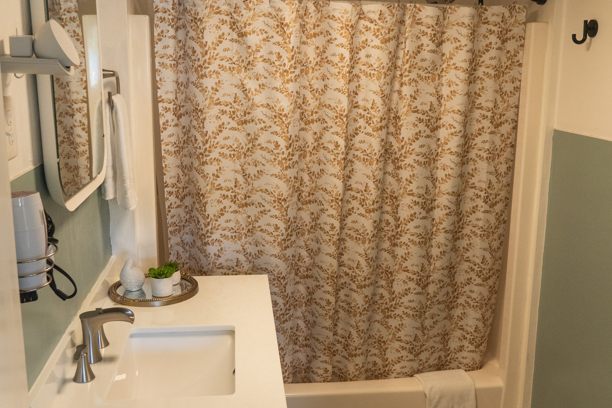 A bright bathroom with a full tub and shower combo, designed for comfort and everyday ease.