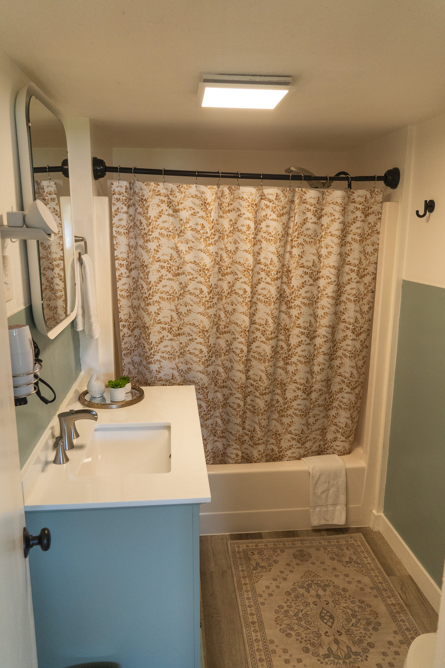 A bright bathroom with a full tub and shower combo, designed for comfort and everyday ease.