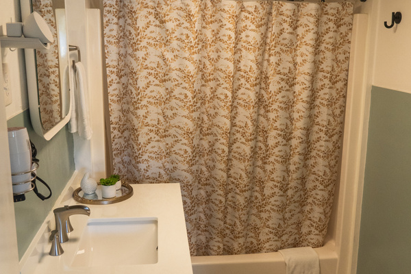 A bright bathroom with a full tub and shower combo, designed for comfort and everyday ease.
