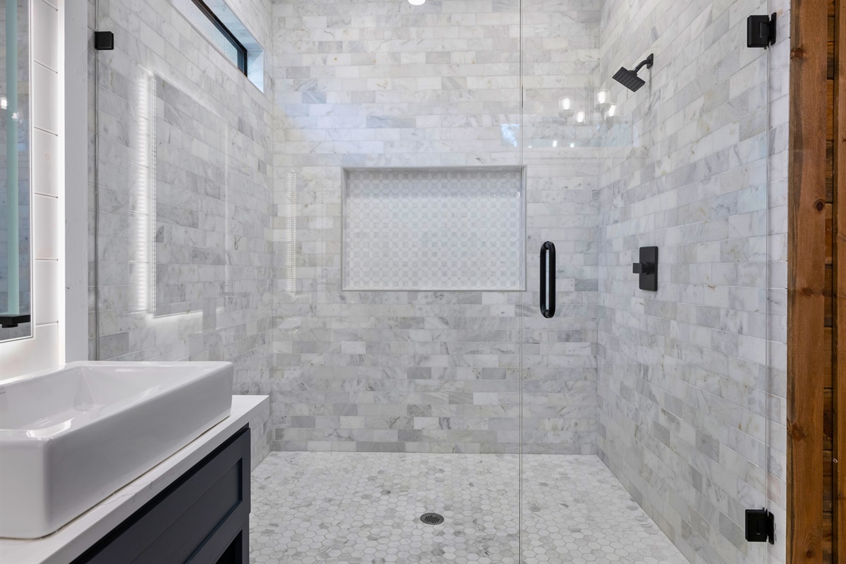 Walk-in shower with sleek tile and glass doors.