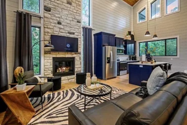Lounge area with smart TV, fireplace, and open kitchen layout.