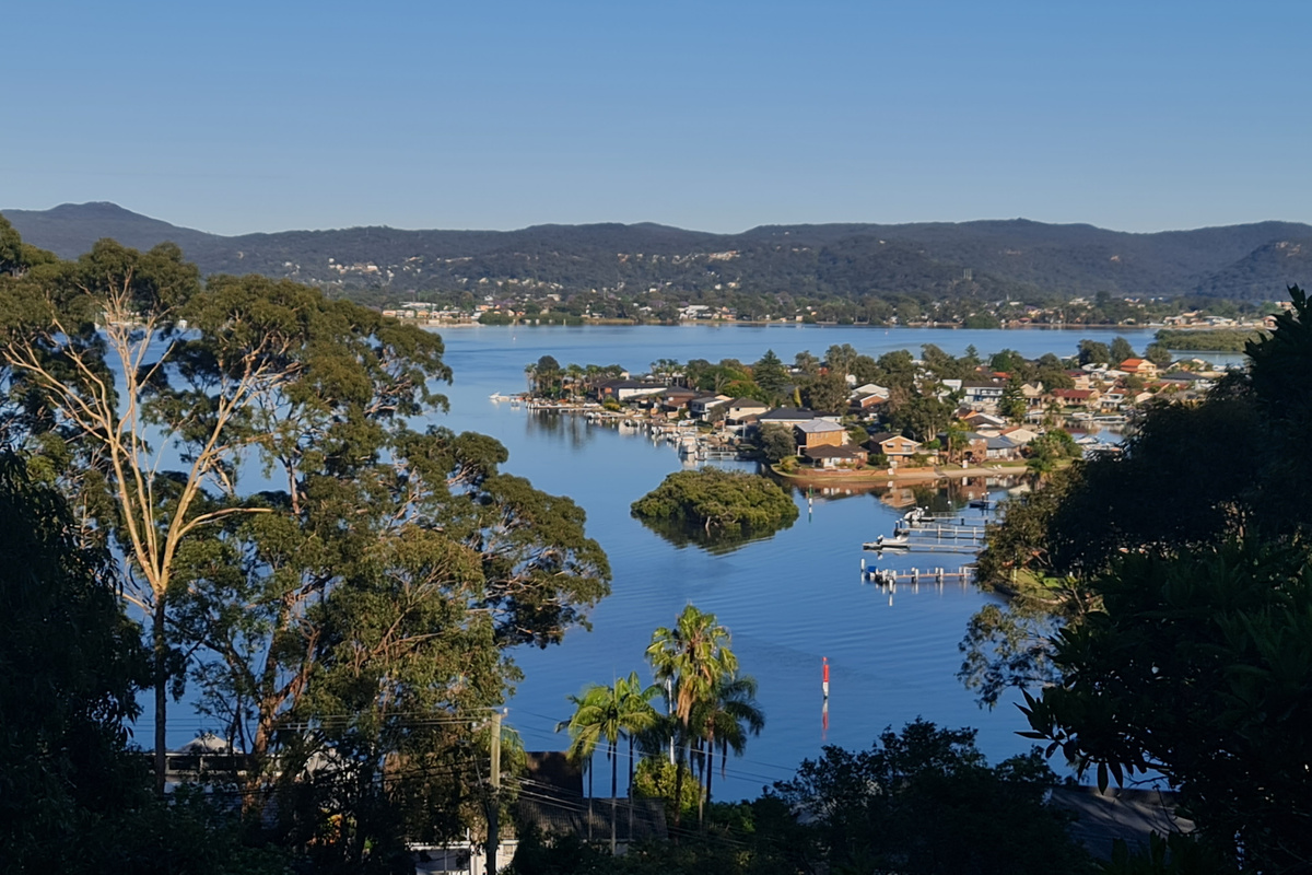 From Carinya Coastal Escapes, the view looks across Brisbane Water toward the waterfront pockets around Ettalong, Booker Bay and the Central Coast.