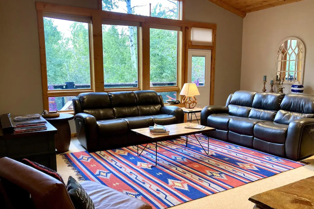 Main floor living room - Great views and a deck nestled in the aspen trees! Comfy couches with four reclining seats, large TV, desk, and open floor plan to kitchen and dining.