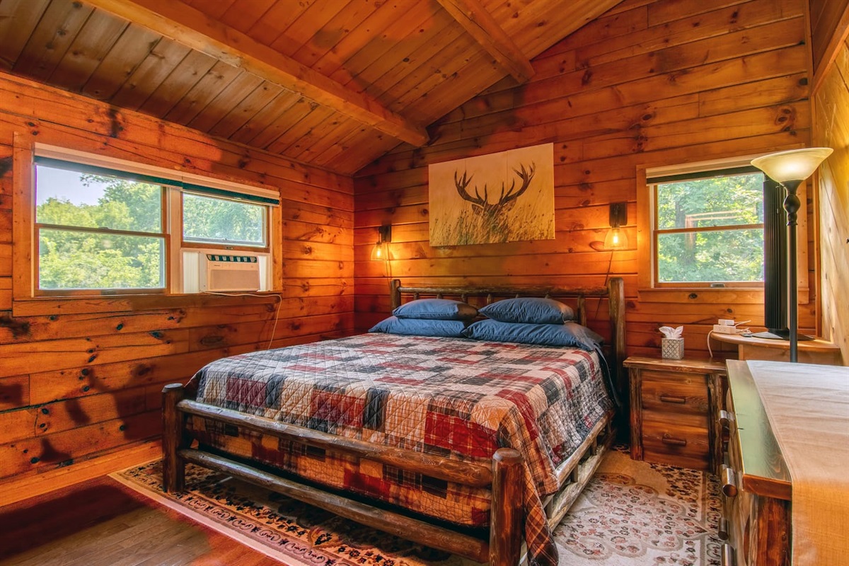 Rustic log furniture: King size bed, 2 bedside tables and dresser. There are two closets. There is a tower fan and window ac unit during the cooling season for added comfort during your stay.