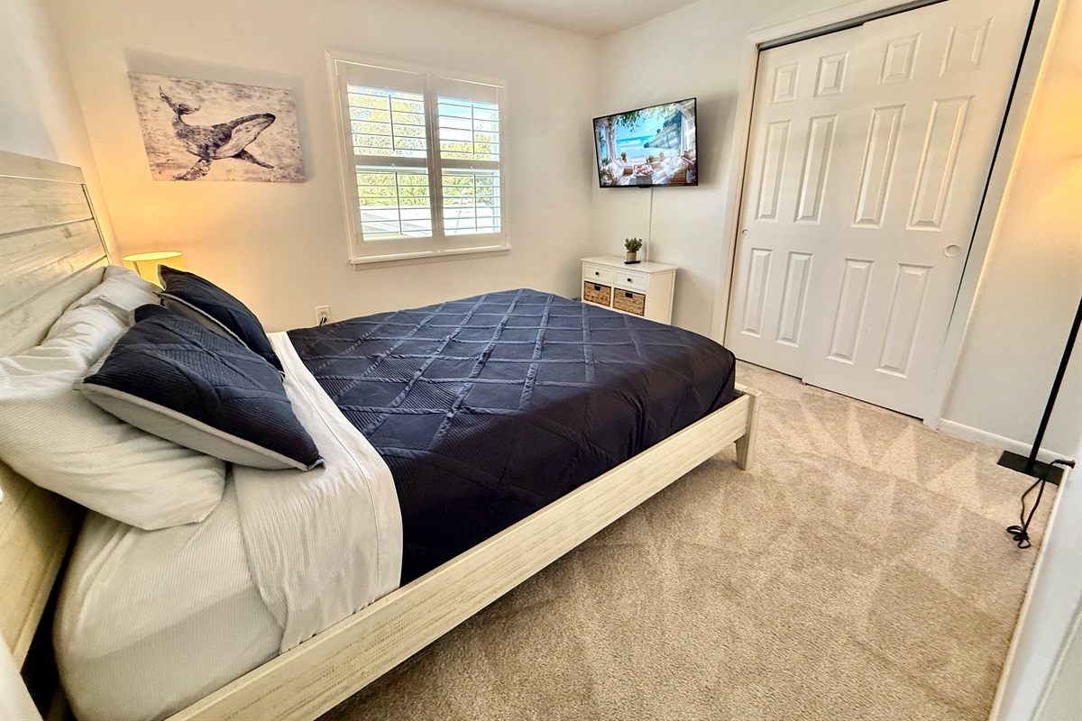 A cozy queen bedroom with a classic, clean design and plenty of natural light.