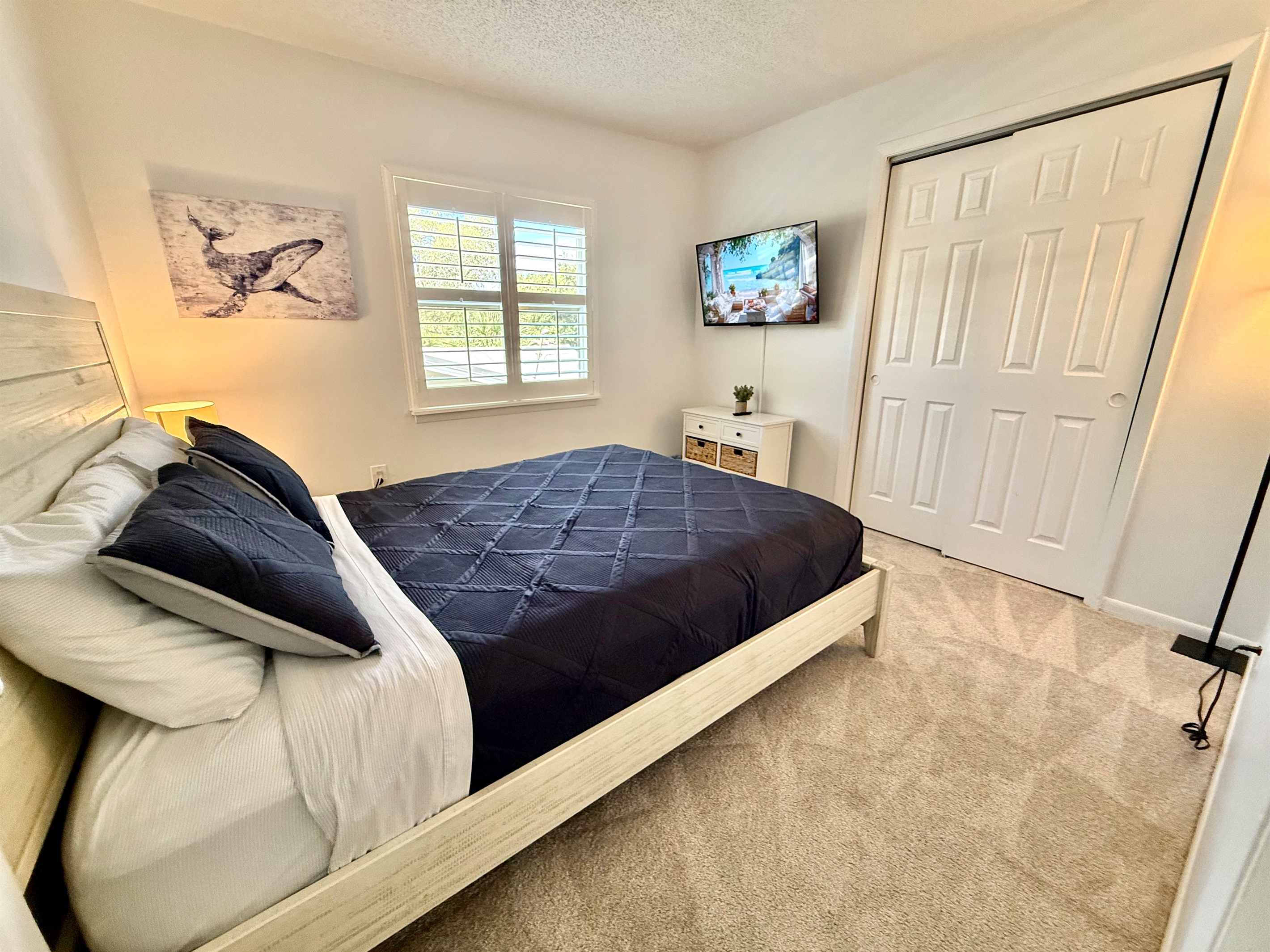 A cozy queen bedroom with a classic, clean design and plenty of natural light.