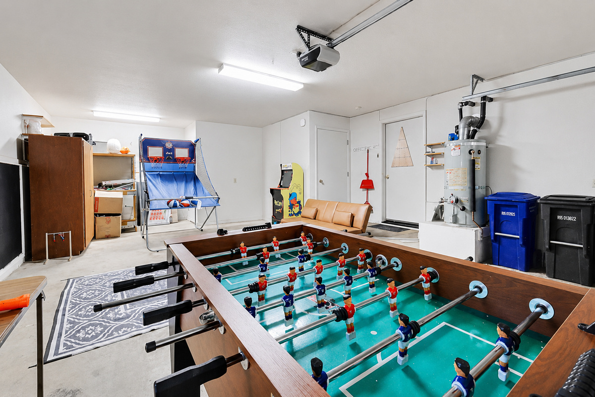Game room garage with foosball, arcade games, lounge seating, and extra space for indoor fun.