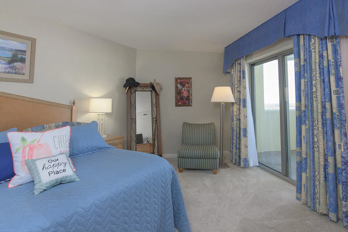 Spacious main bedroom with king bed, balcony access and ensuite