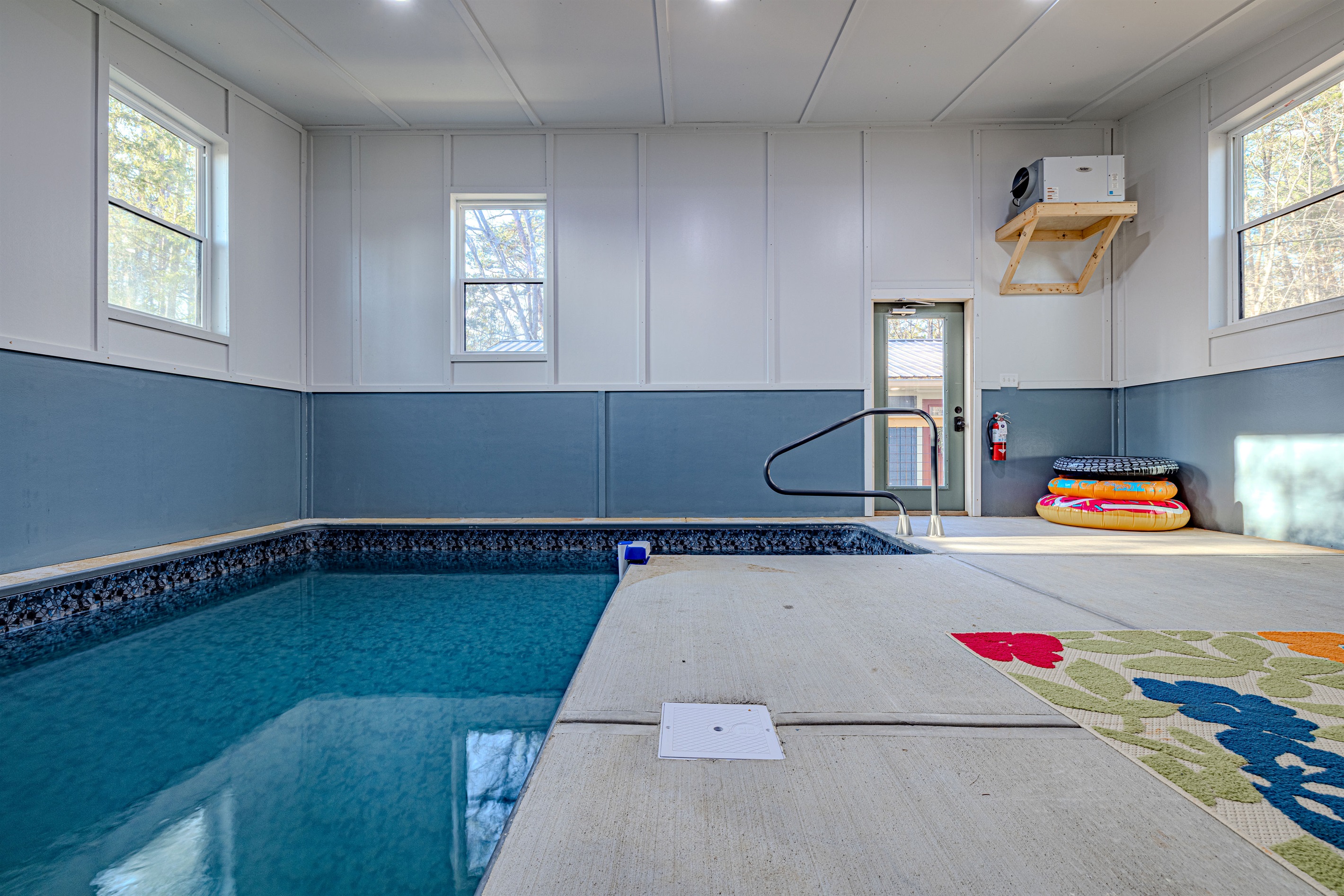 Swim, splash, and lounge! Our private indoor pool area features comfortable seating, pool toys, and a vibrant rug for fun.