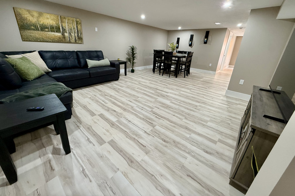Living room in basement with heated floors and 65” TV