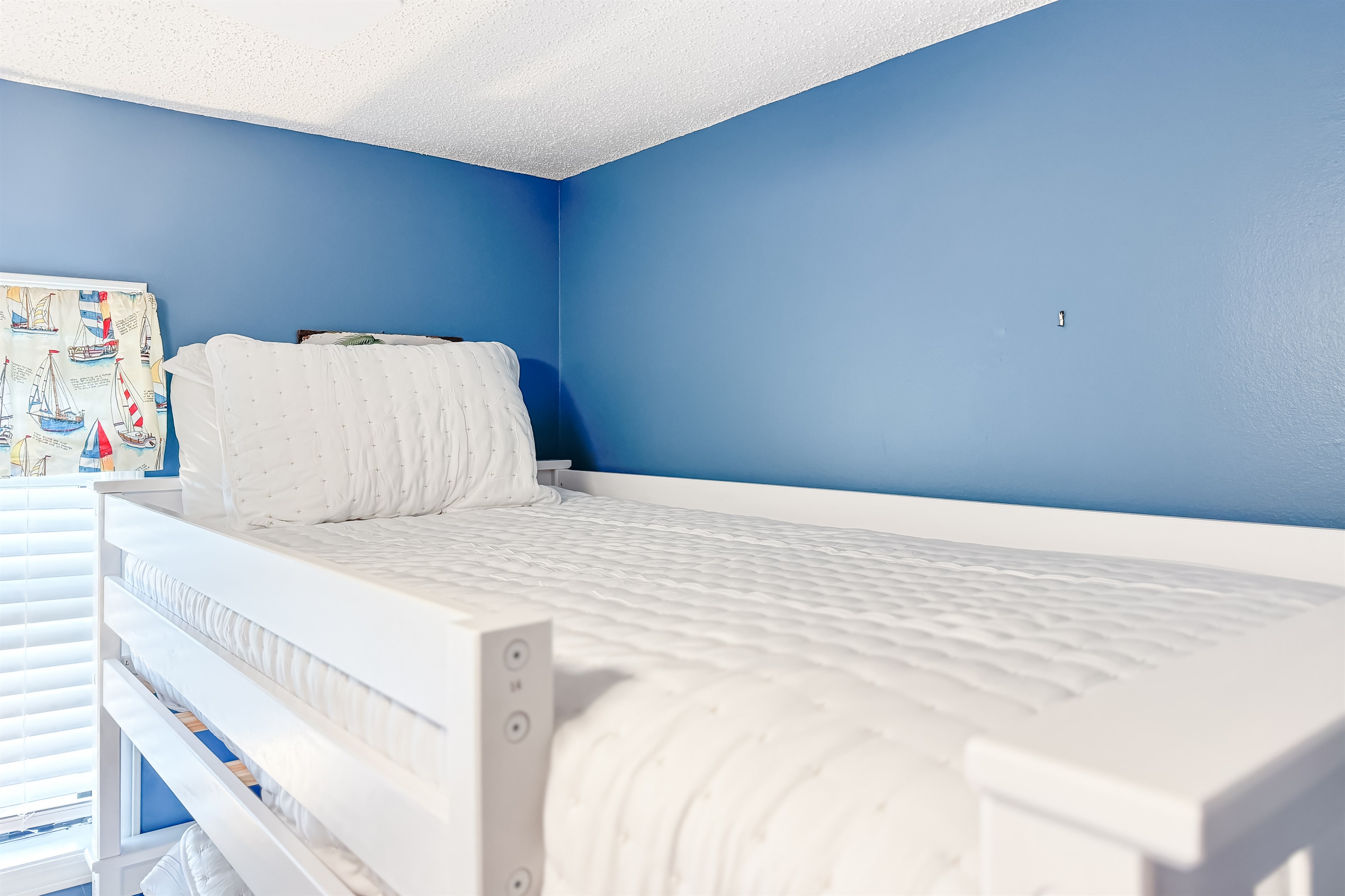 Versatile guest room with bunk bed and queen-size bed offering comfortable accommodations for guests or family. This space maximizes functionality and style, providing a cozy and inviting atmosphere.