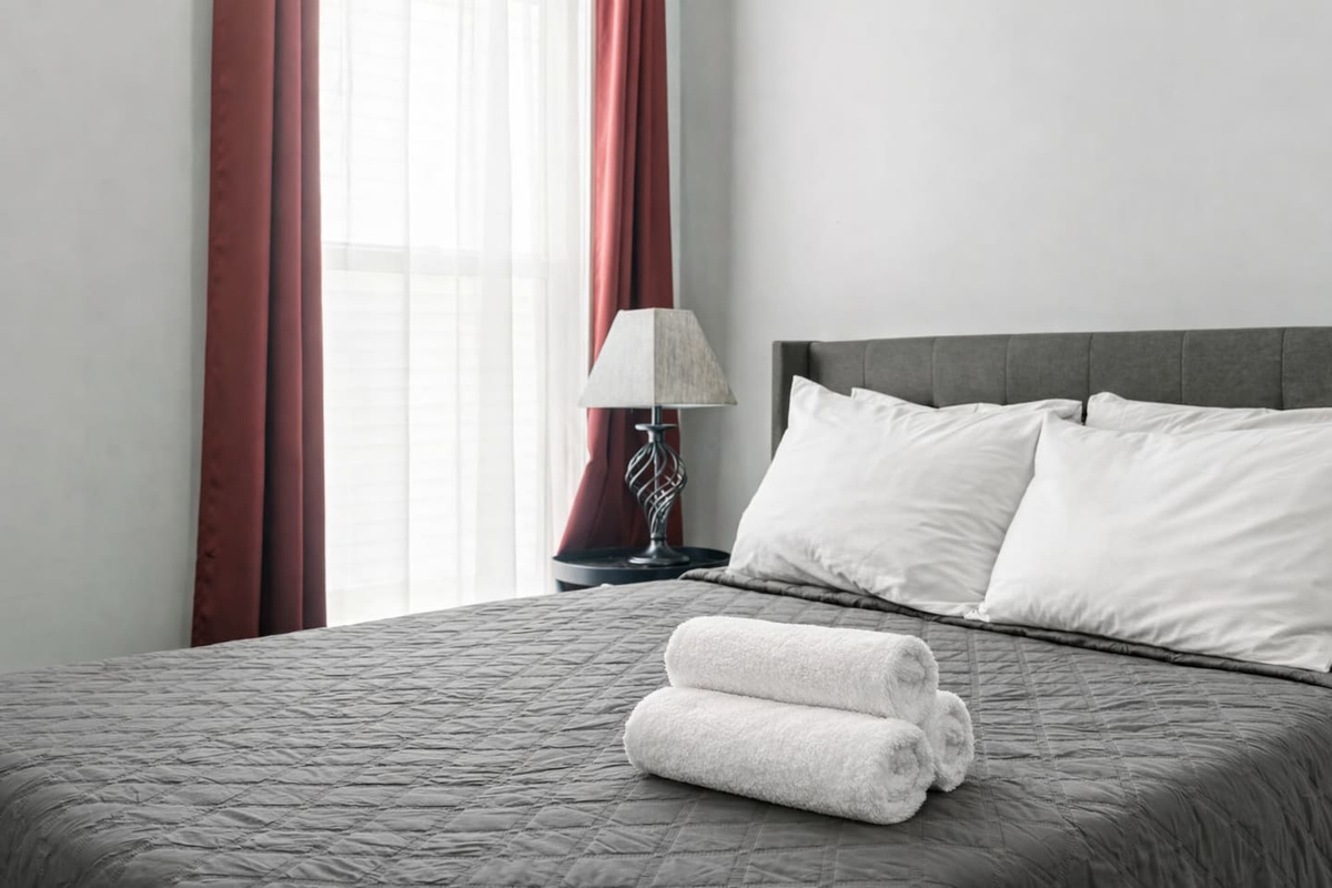 Close-up of the full-size bed with fresh linens and bedside lamp, creating a cozy sleep space.