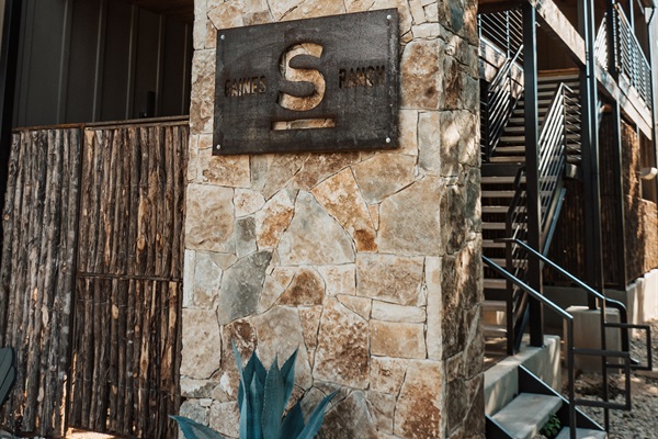 Arriving at Gaines Ranch on the Square &mdash; the property's signature mark on Hill Country stone, with stair access to the upstairs suites.