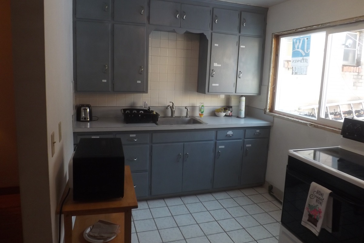 Full kitchen with refrigerator, stove, microwave, coffee makers, and most essentials