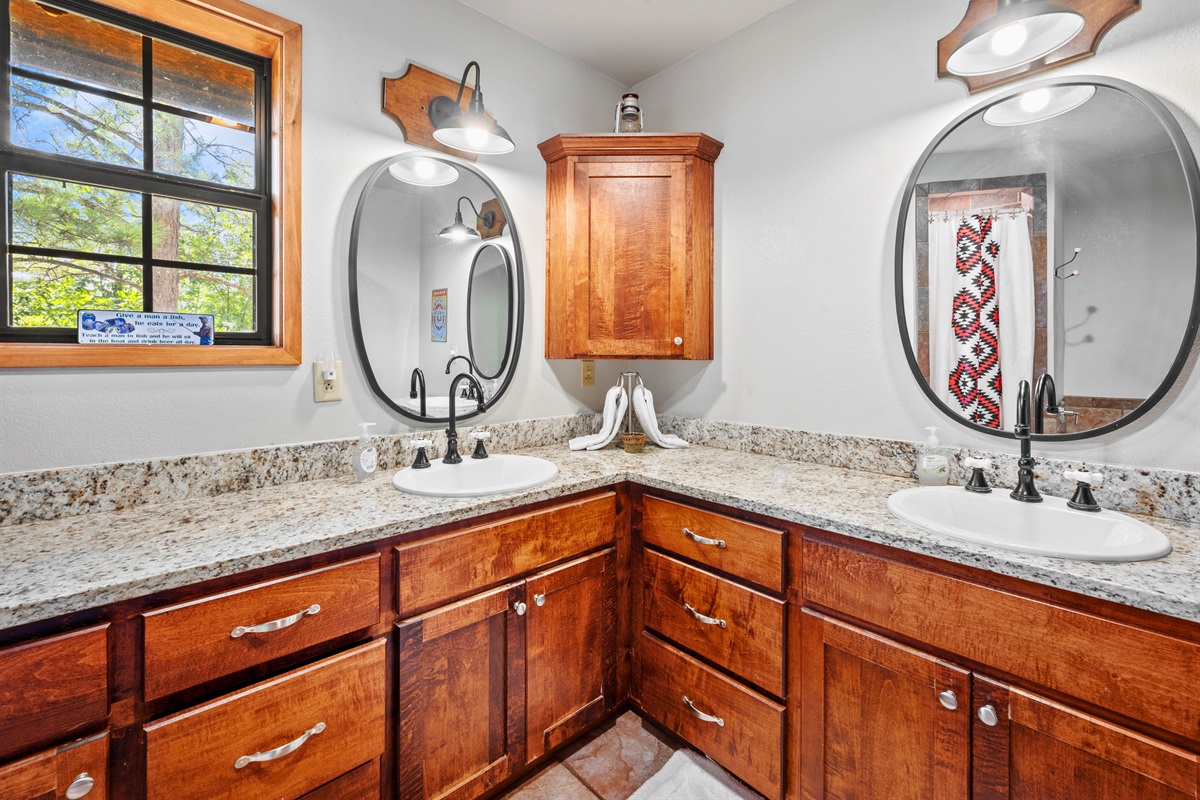 Well-lit second bathroom with ample storage and dual sinks.