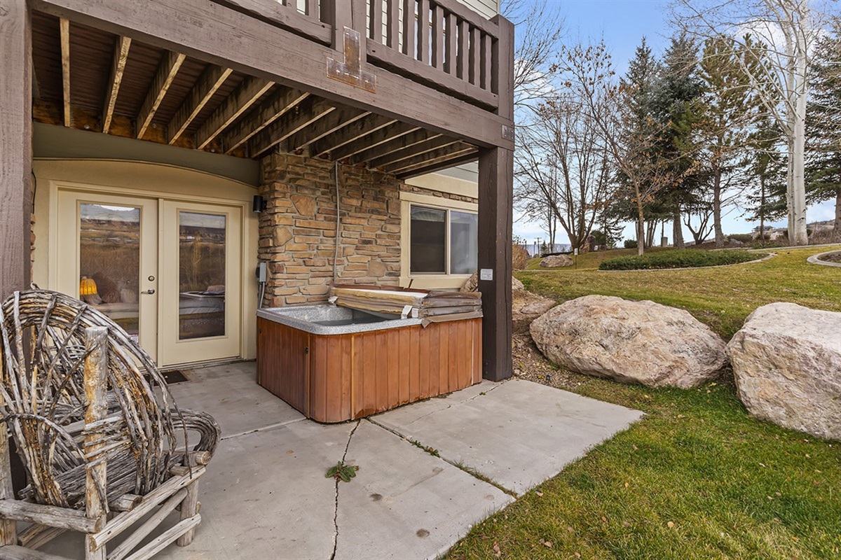 A private patio with hot tub and outdoor seating, blending comfort and nature for an elevated outdoor living experience.