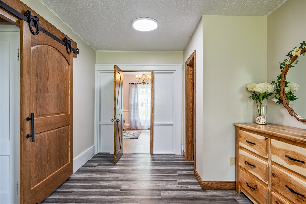 Modern rustic charm meets functionality in this bright hallway featuring barn doors and natural wood accents.