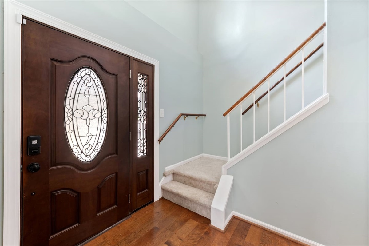 The welcoming entryway features rich wood tones, natural light, and easy flow into the rest of the home.