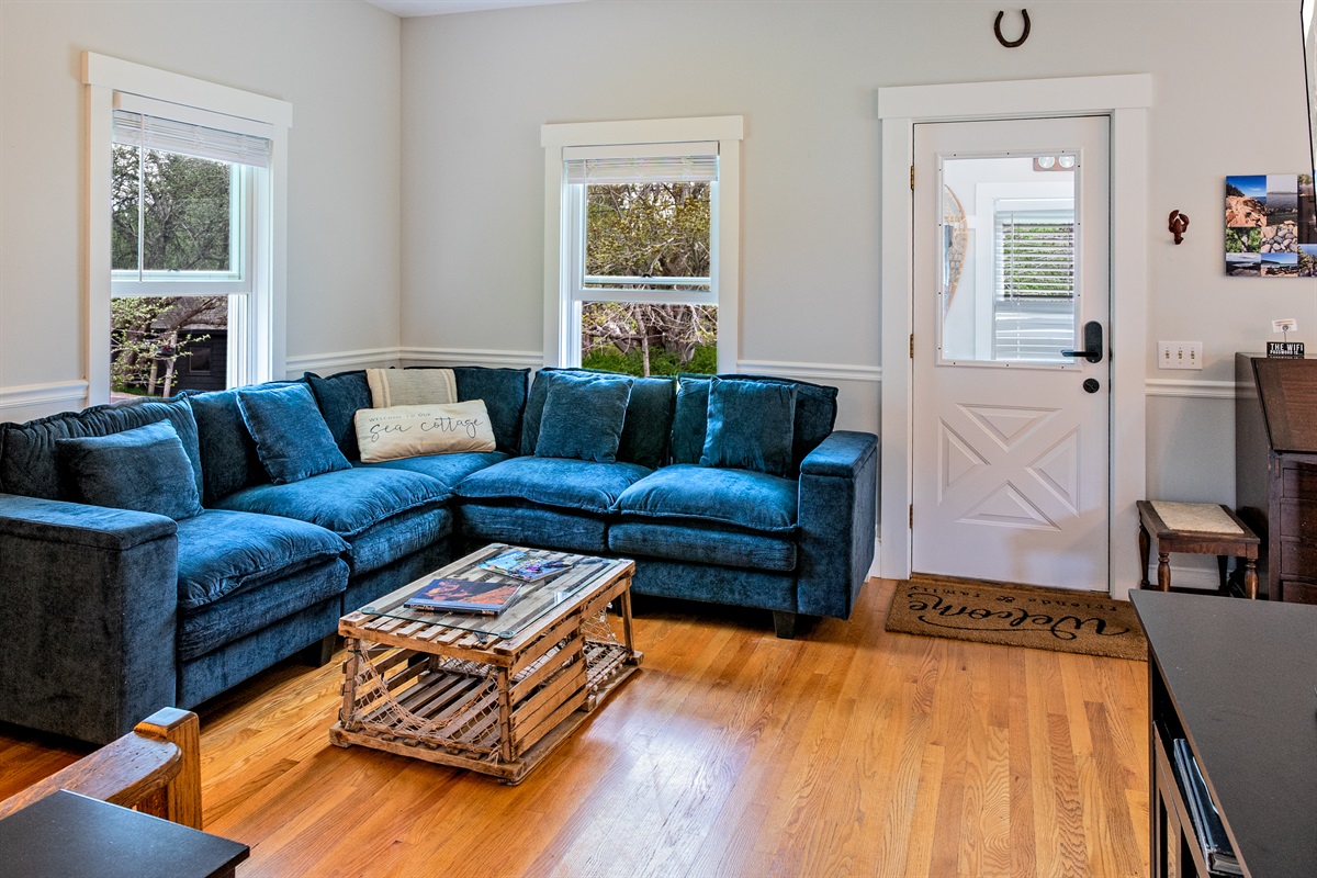 Seamless indoor-outdoor flow. This view shows our new navy sectional in relation to the main entryway—perfect for dropping your gear and relaxing instantly. A bright, pet-friendly hub in historic Hall Quarry on the MDI Quiet Side.