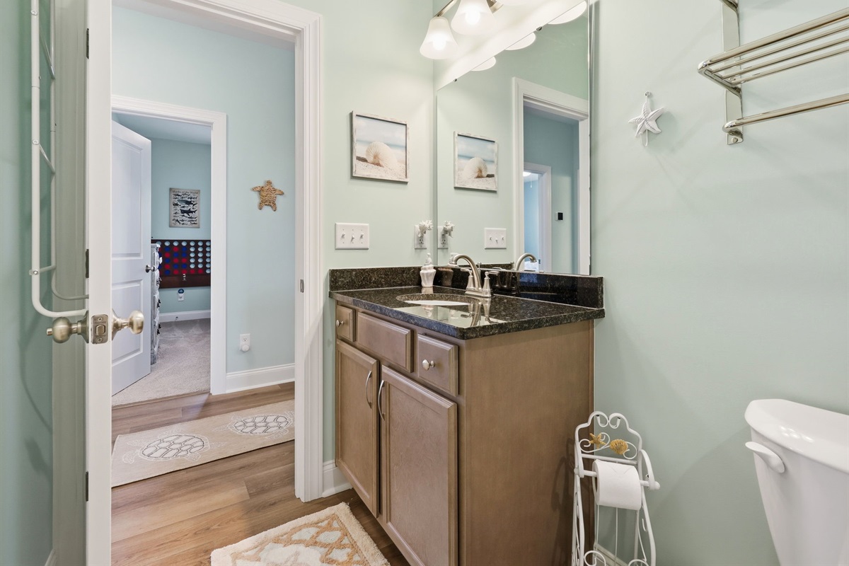 Full bathroom with granite vanity, bright lighting, and easy access from hallway