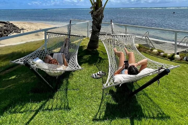 Your own two-person double capacity hammock to smells and listen to the melodious waves. Guests of home in the background in the ocean are standing in the waist-deep crystal-clear water of the snorkeling reef.